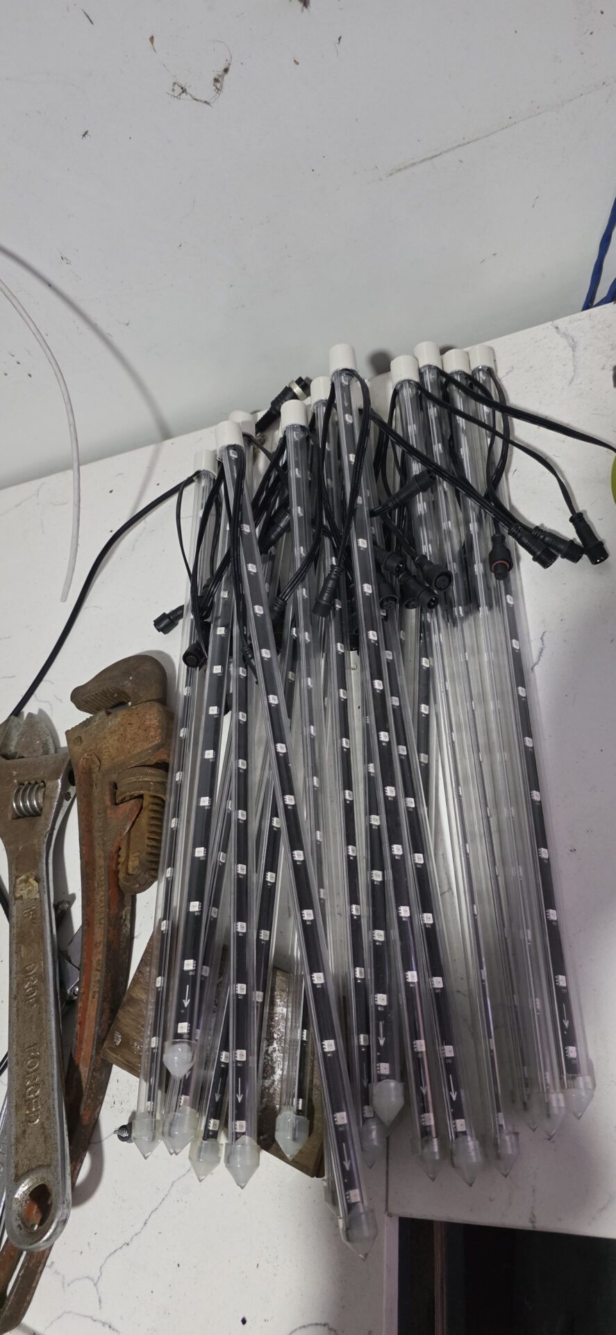 Finished meteor sticks, LED strip and tube with pigtail connectors, laid out on the bench